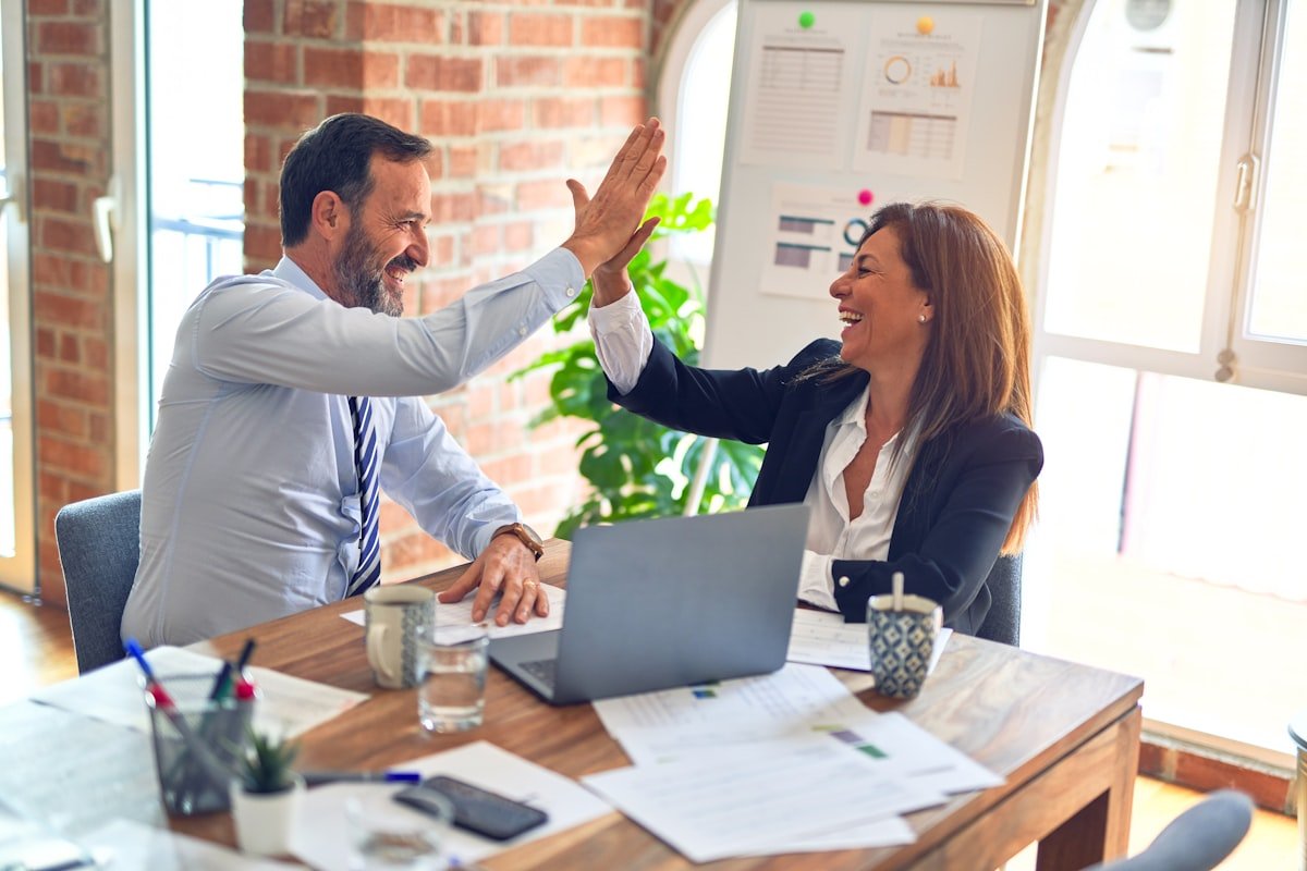 Two colleagues celebrating a project win